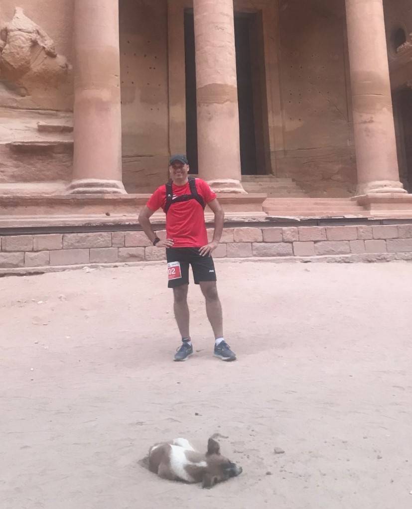 A runner and a dog at the start line of the Petra Desert Marathon