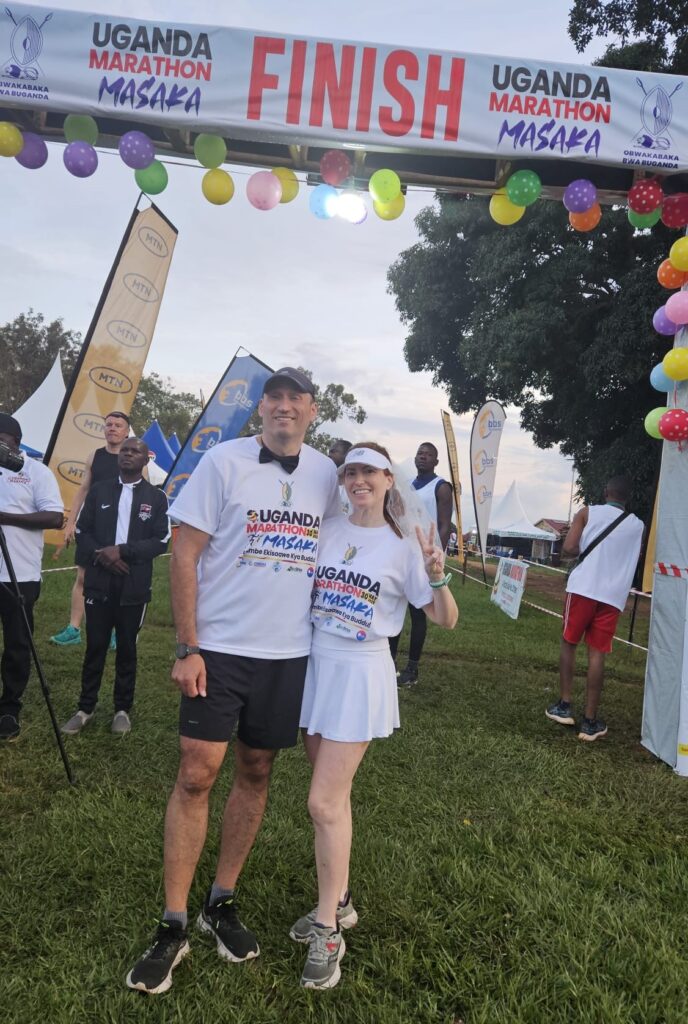 Running the Uganda Marathon in Masaka, Uganda, in May 2025, for our honeymmon, dressed as bride and groom. Starting line.