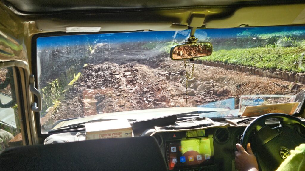 A jeep driving in a very difficult road to enter the Botanical Gardens in Entebbe, Uganda, in 2025