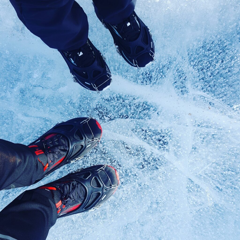 Winter running shoes and spikes for cold weather running. Solomon shoes on top of a frozen lake in Norway for the Frozen Lake Marathon